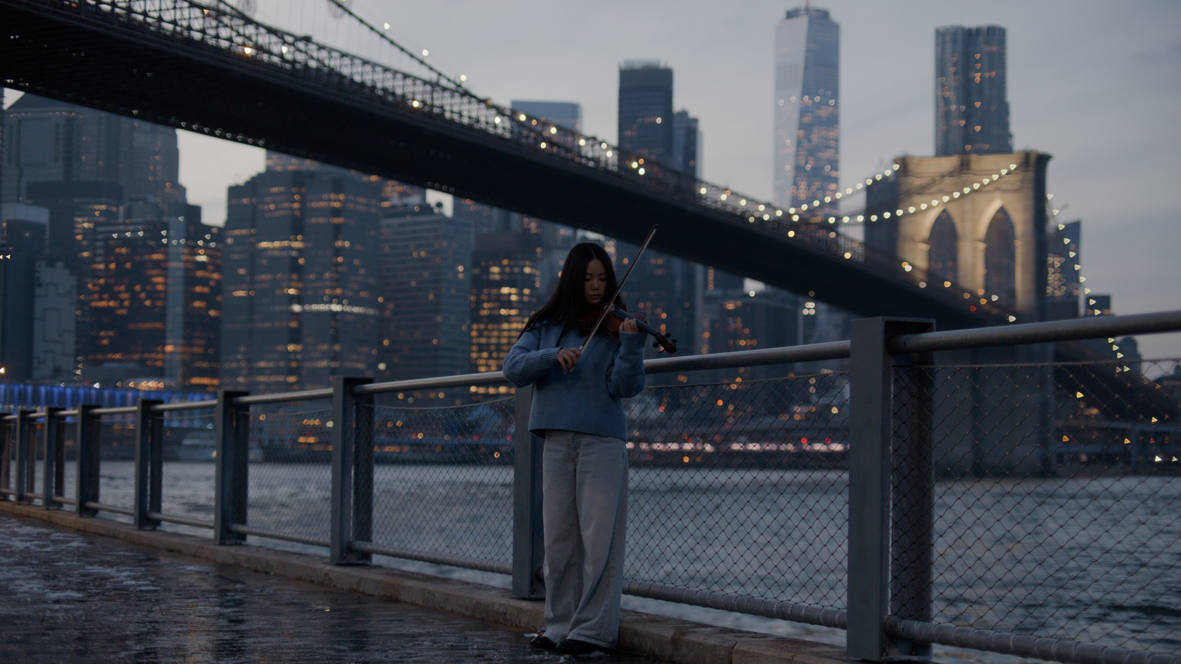 Concerto film still with violinist near Brooklyn Bridge