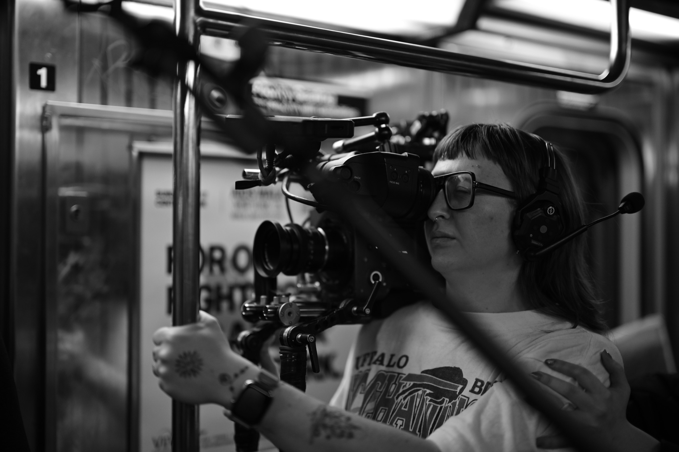 Black and white image of camera operator on subway